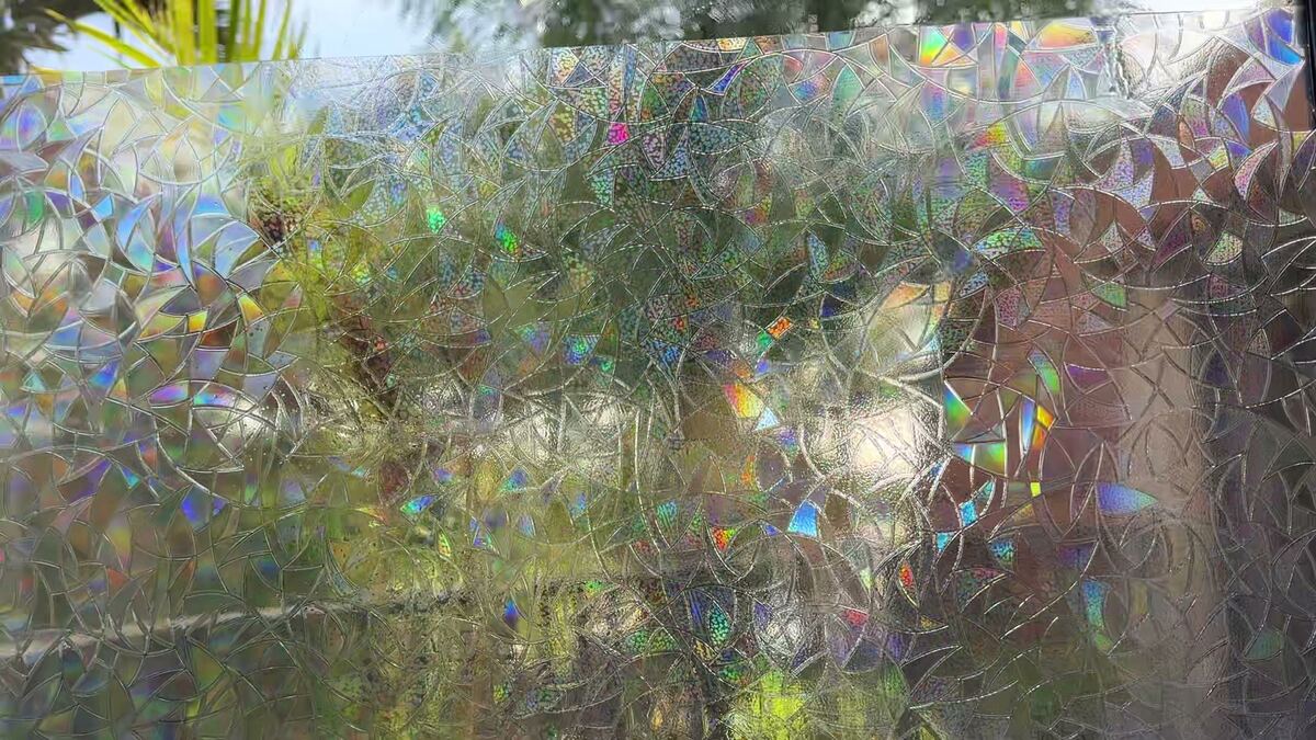 Rainbow film freshly installed on a sunny window, sparkling with small rainbow colors.